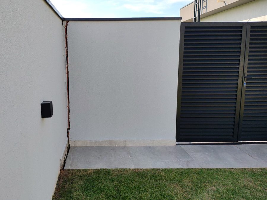 Fissura vertical no encontro entre muro e alvenaria de residência, registrada em vistoria técnica de engenharia
